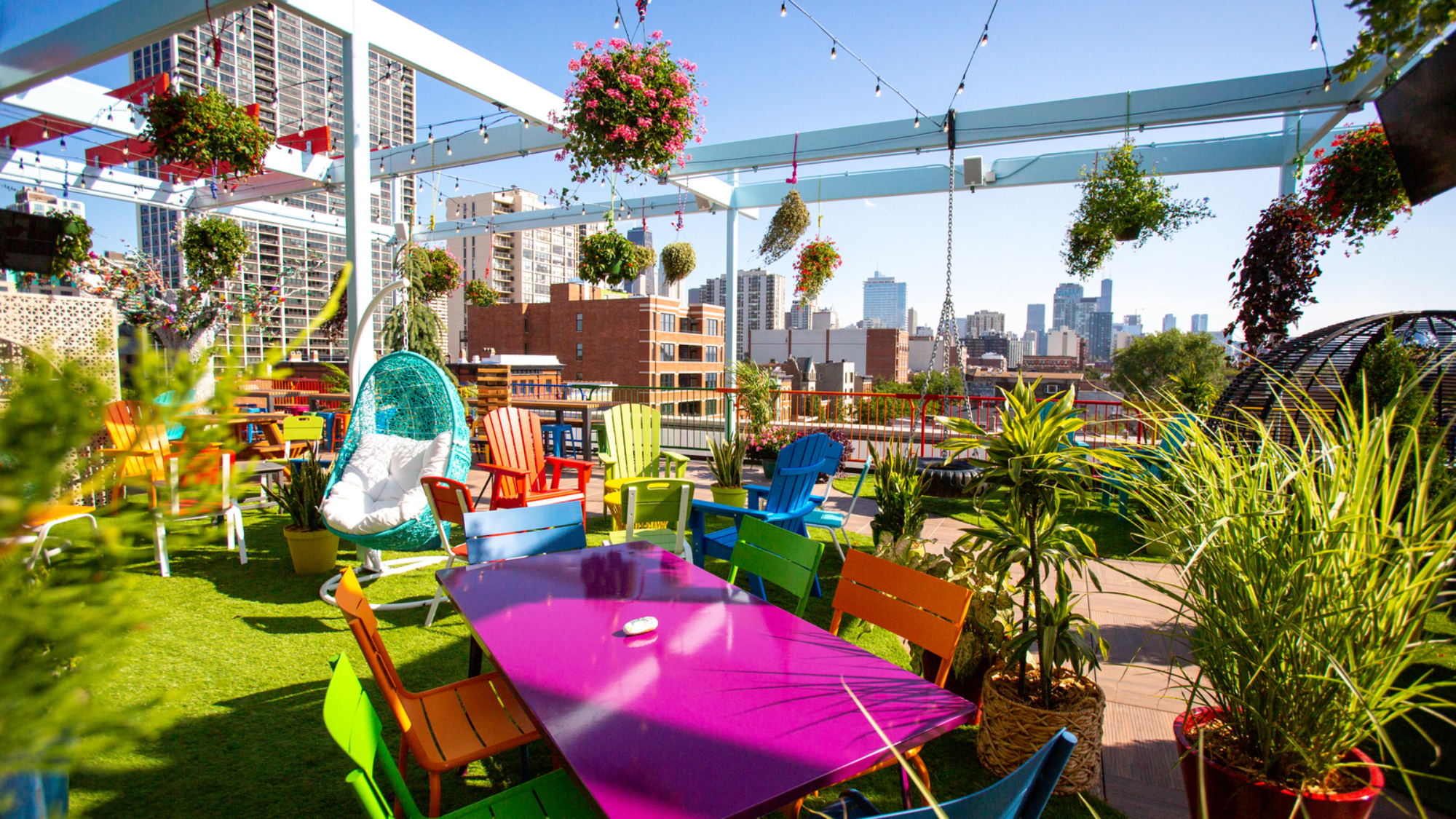 Utopian Tailgate rooftop in Old Town Chicago with colorful seating, hanging plants, and skyline views